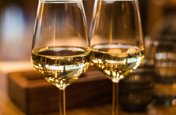 Two elegant wine glasses filled with white wine, captured with a beautiful bokeh effect.