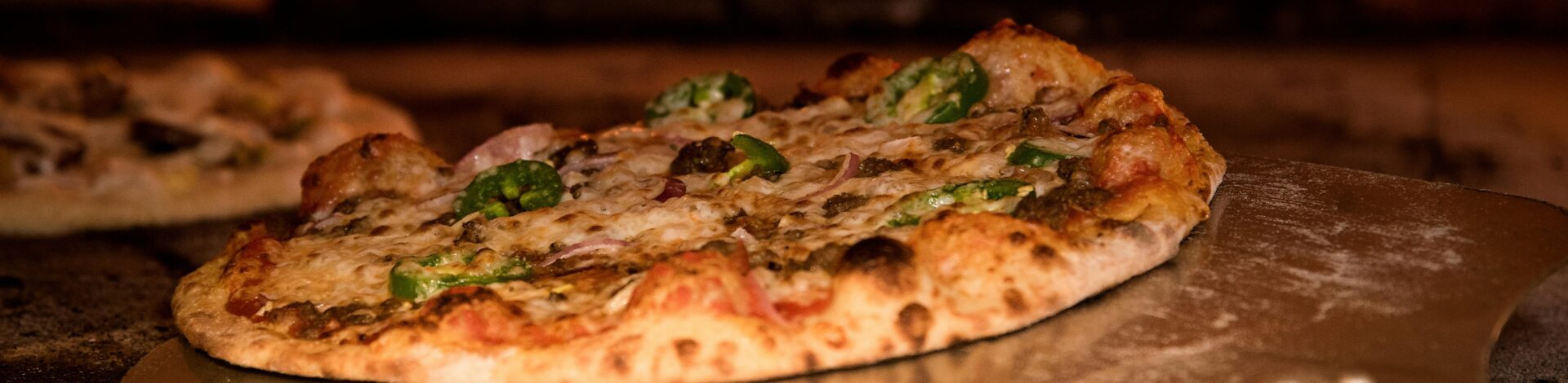 Appetizing gourmet pizza cooked in a wood-fired oven, showcasing artisanal toppings.