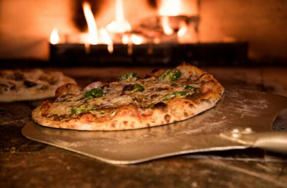 Appetizing gourmet pizza cooked in a wood-fired oven, showcasing artisanal toppings.
